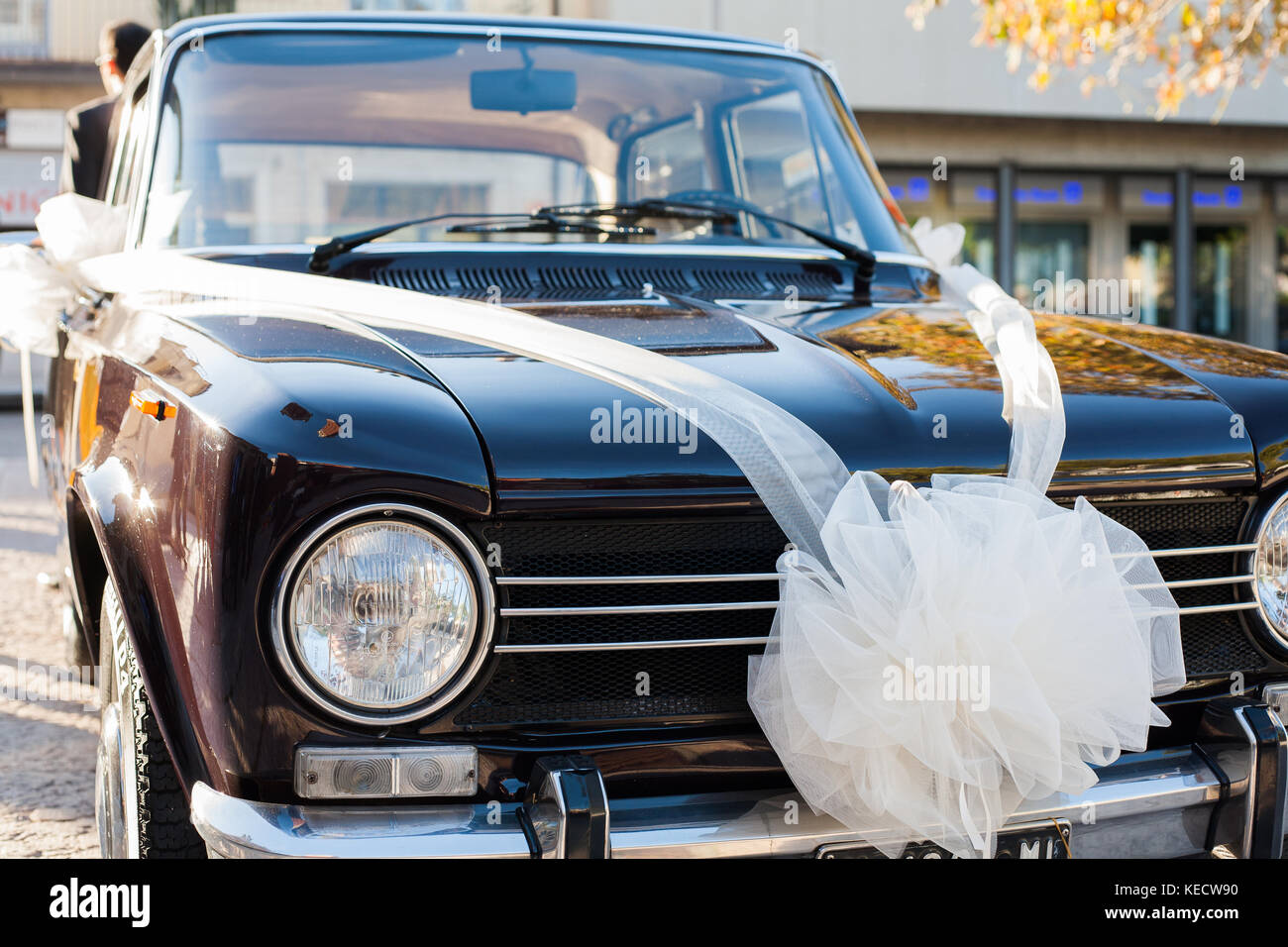 Vintage luxury car ready for wedding day, with clean body and a white ribbon representing the bride's car. Stock Photo