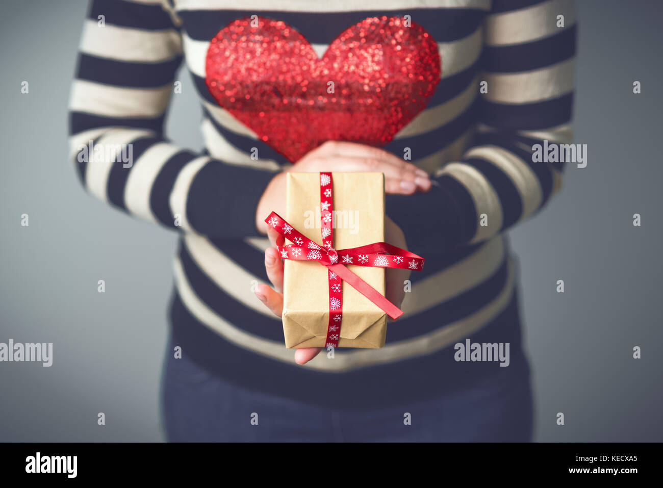 Girl holding a box with a Christmas present Stock Photo - Alamy