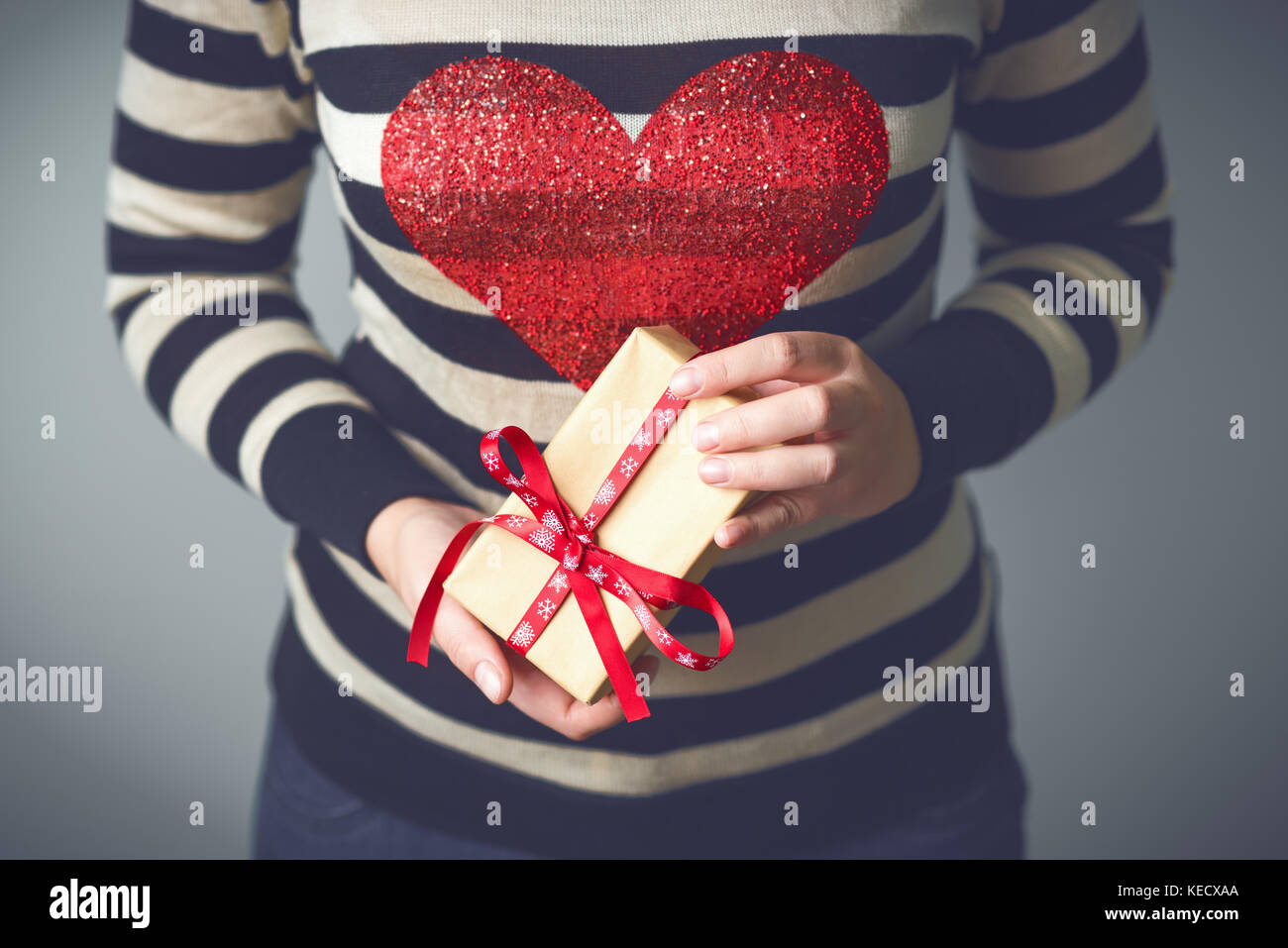 Girl holding a box with a Christmas present Stock Photo - Alamy