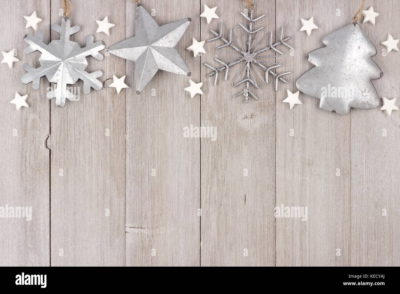 Christmas top border with shabby chic handmade clay and metal ornaments on a rustic wood background Stock Photo