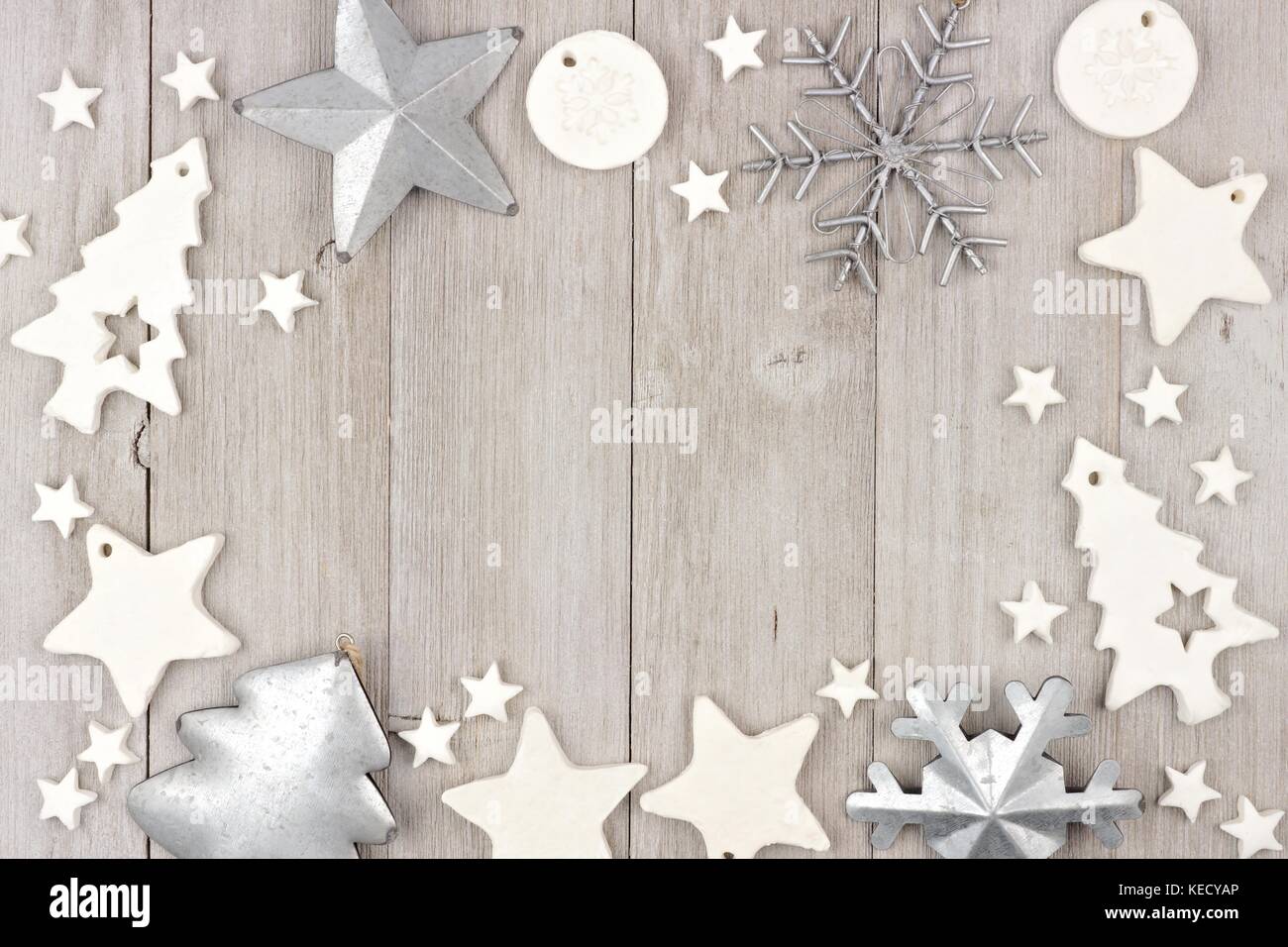 Christmas frame with shabby chic handmade clay and metal ornaments on a rustic wood background Stock Photo