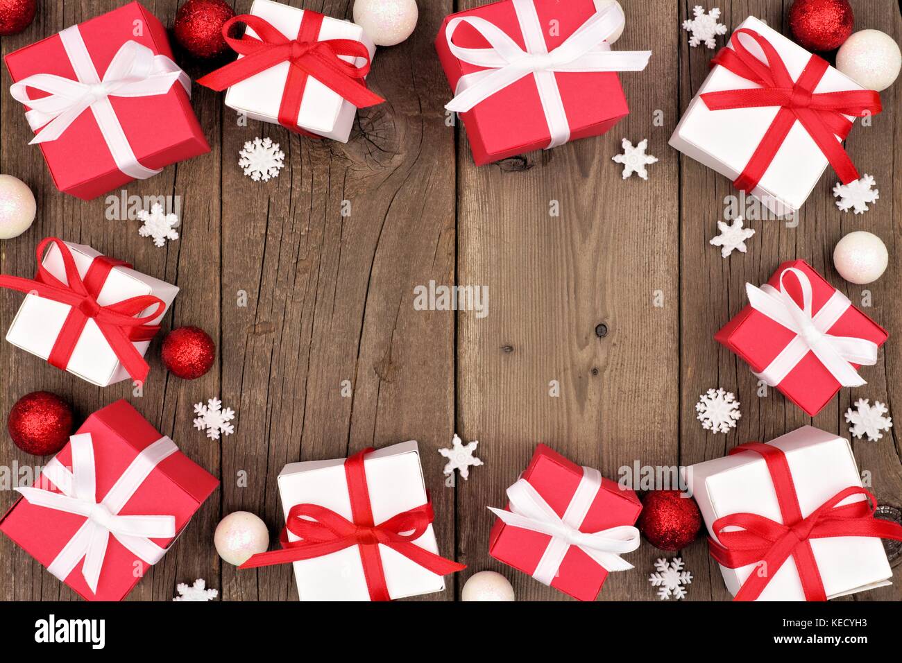 Red and white Christmas gift box frame over a rustic wood background Stock Photo