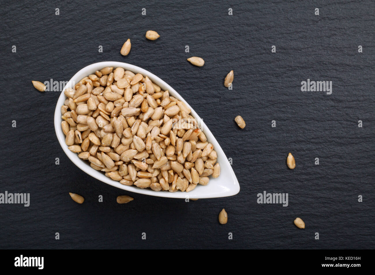 Organic sunflower seeds on black slate stone background with copy space Stock Photo