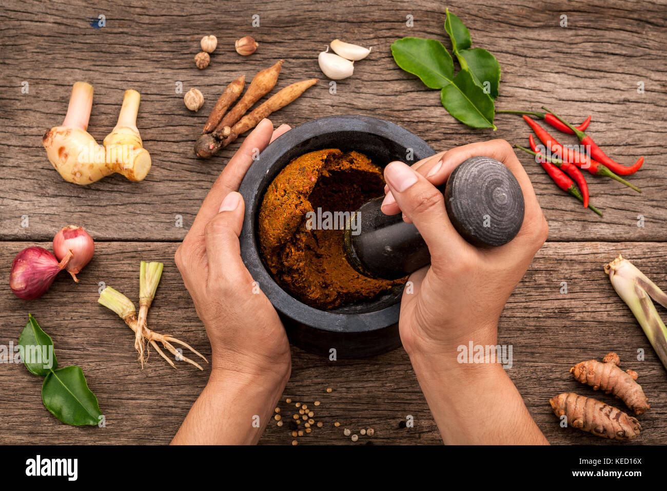 The Women hold pestle with mortar and spice red curry paste ingredient