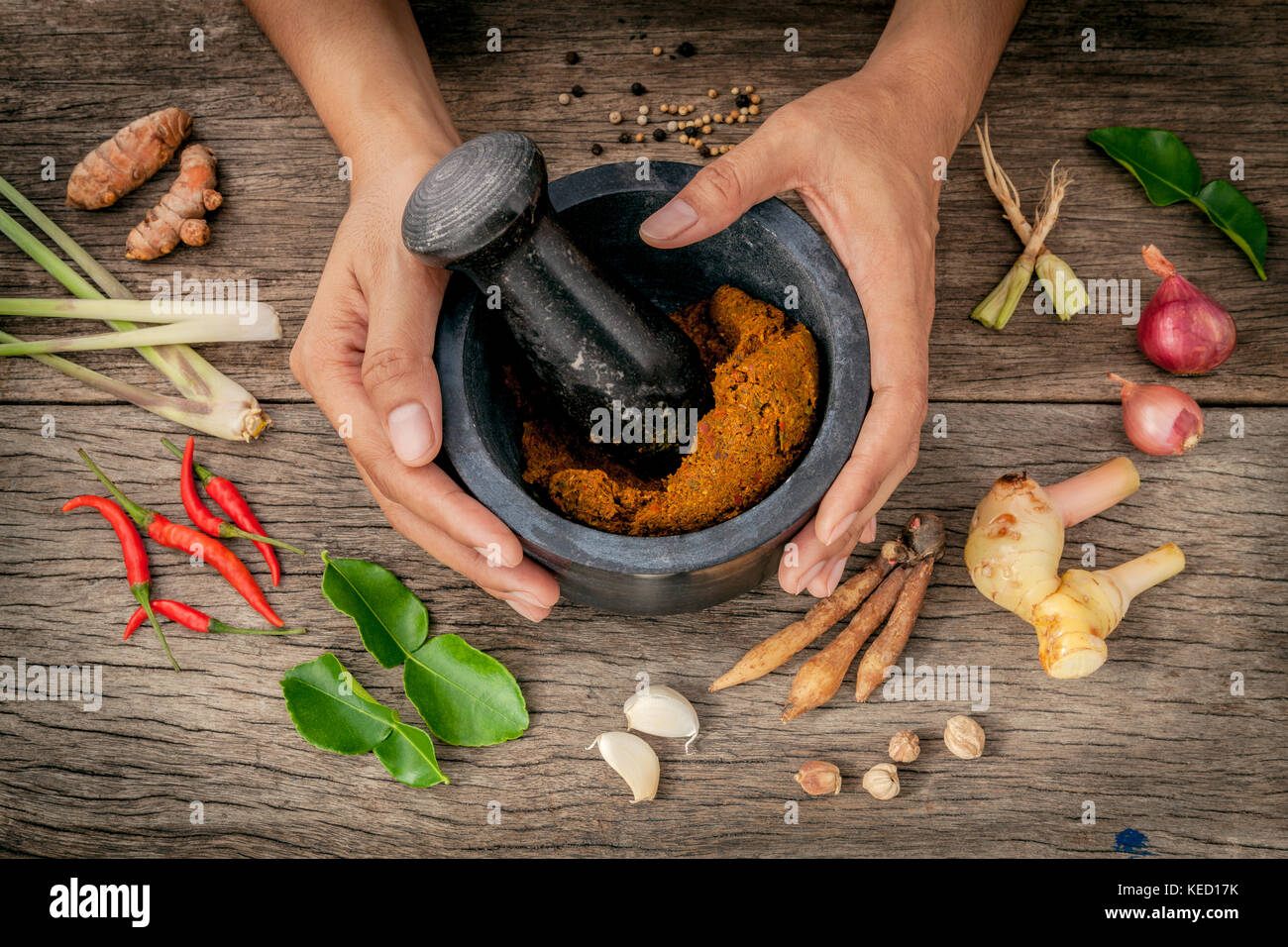 The Women hold pestle with mortar and spice red curry paste ingredient