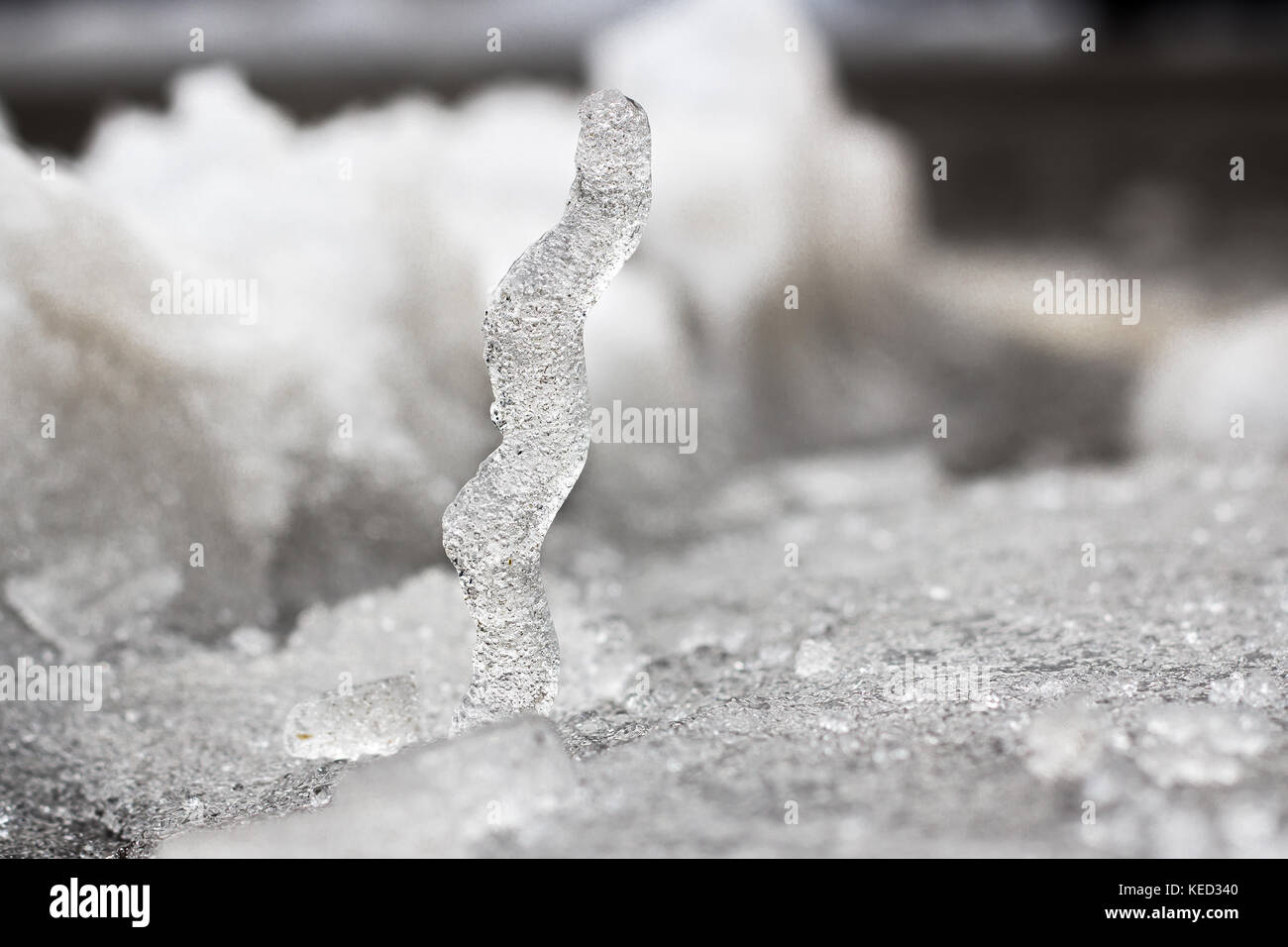 Ice column standing on snow, winter background Stock Photo