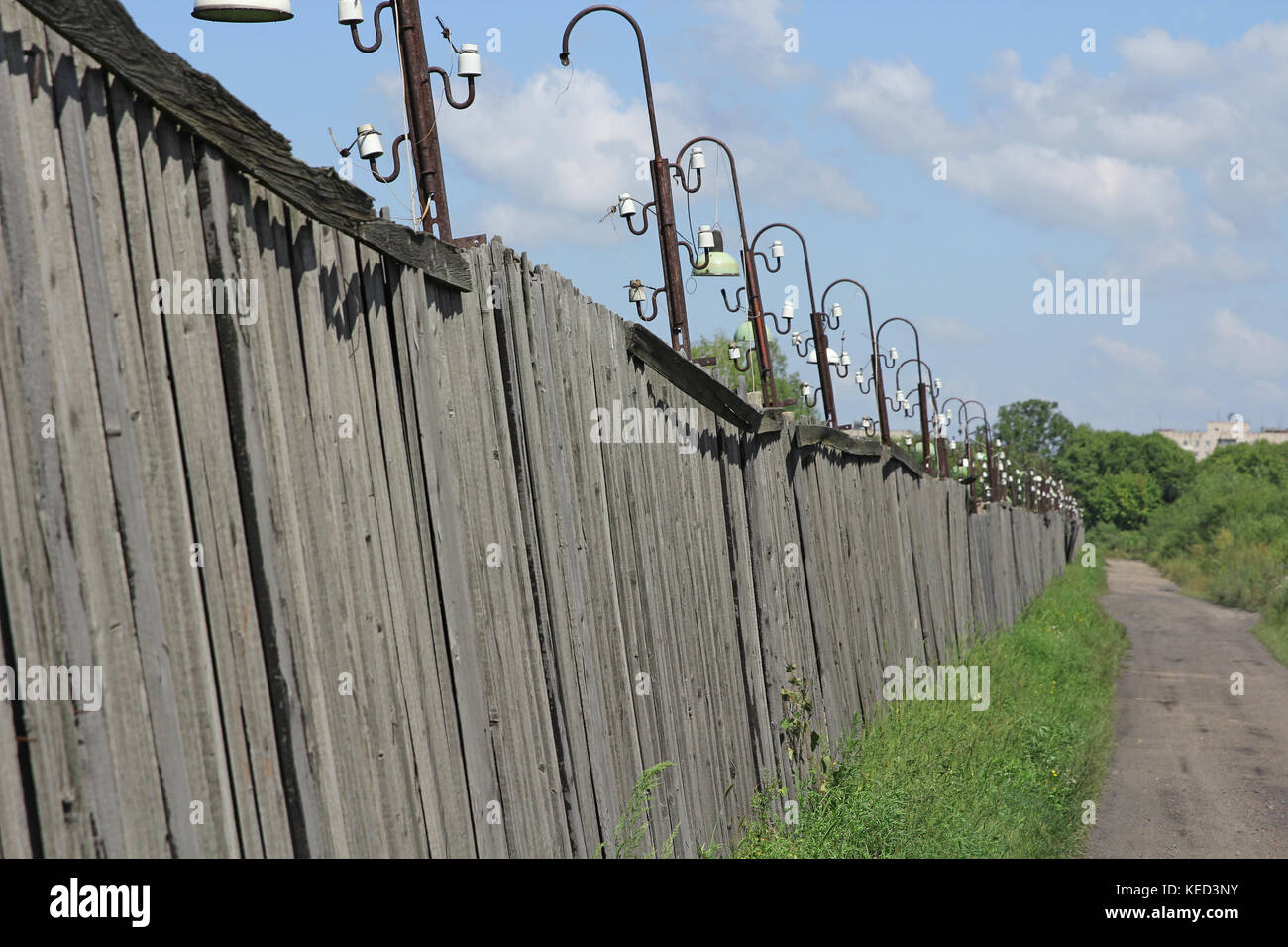 Metal fence wire, grass and sky in the background Stock Photo - Alamy