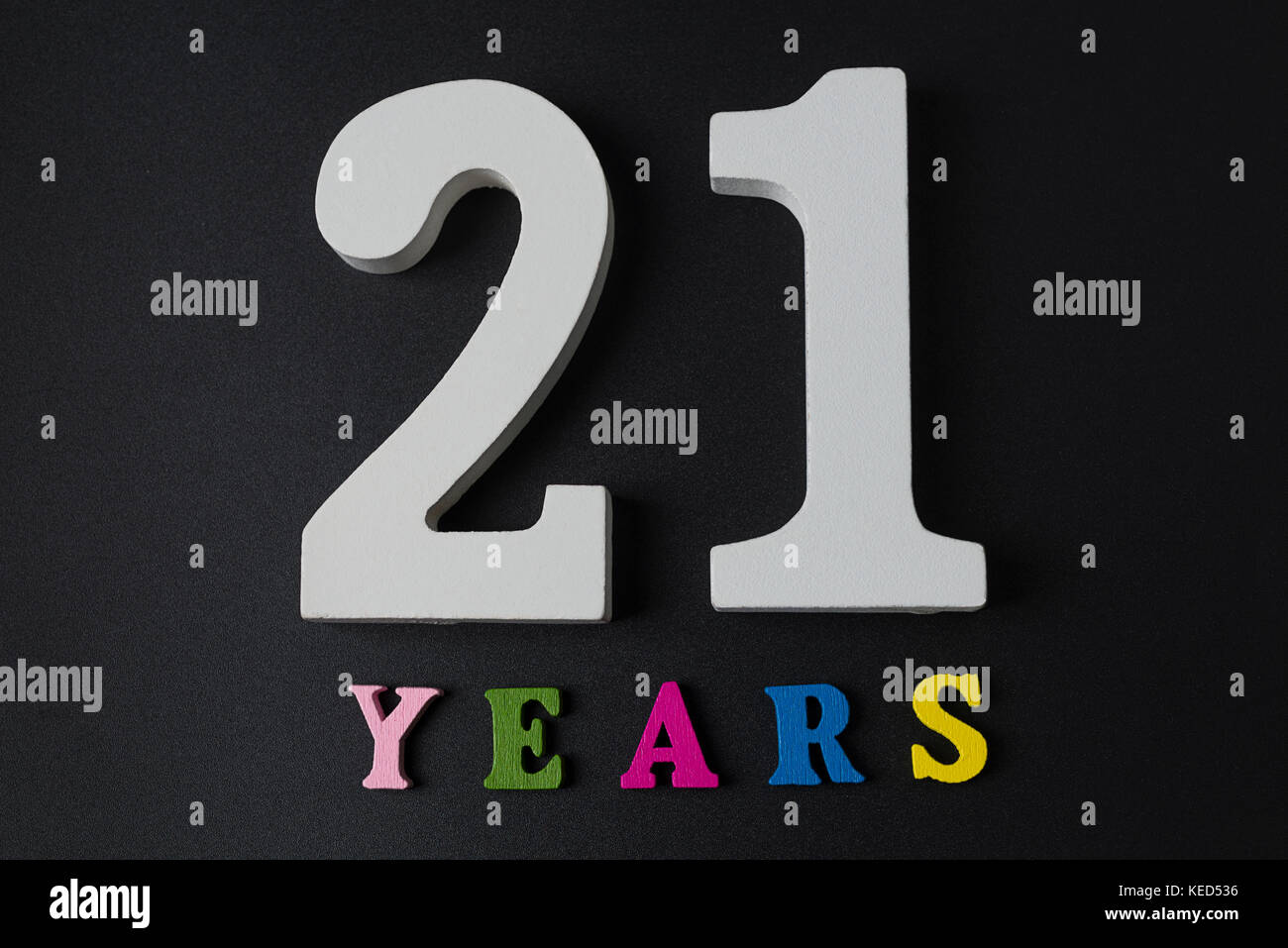 Letters and numbers twenty-one years on black isolated background. Stock Photo