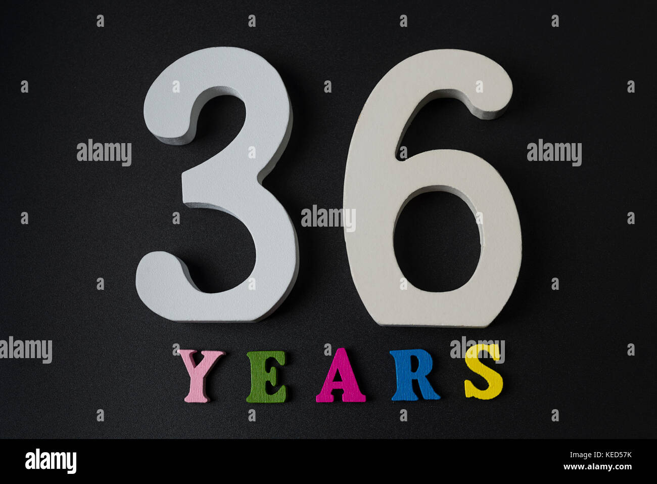 Letters and numbers thirty-six years on a black isolated background. Stock Photo