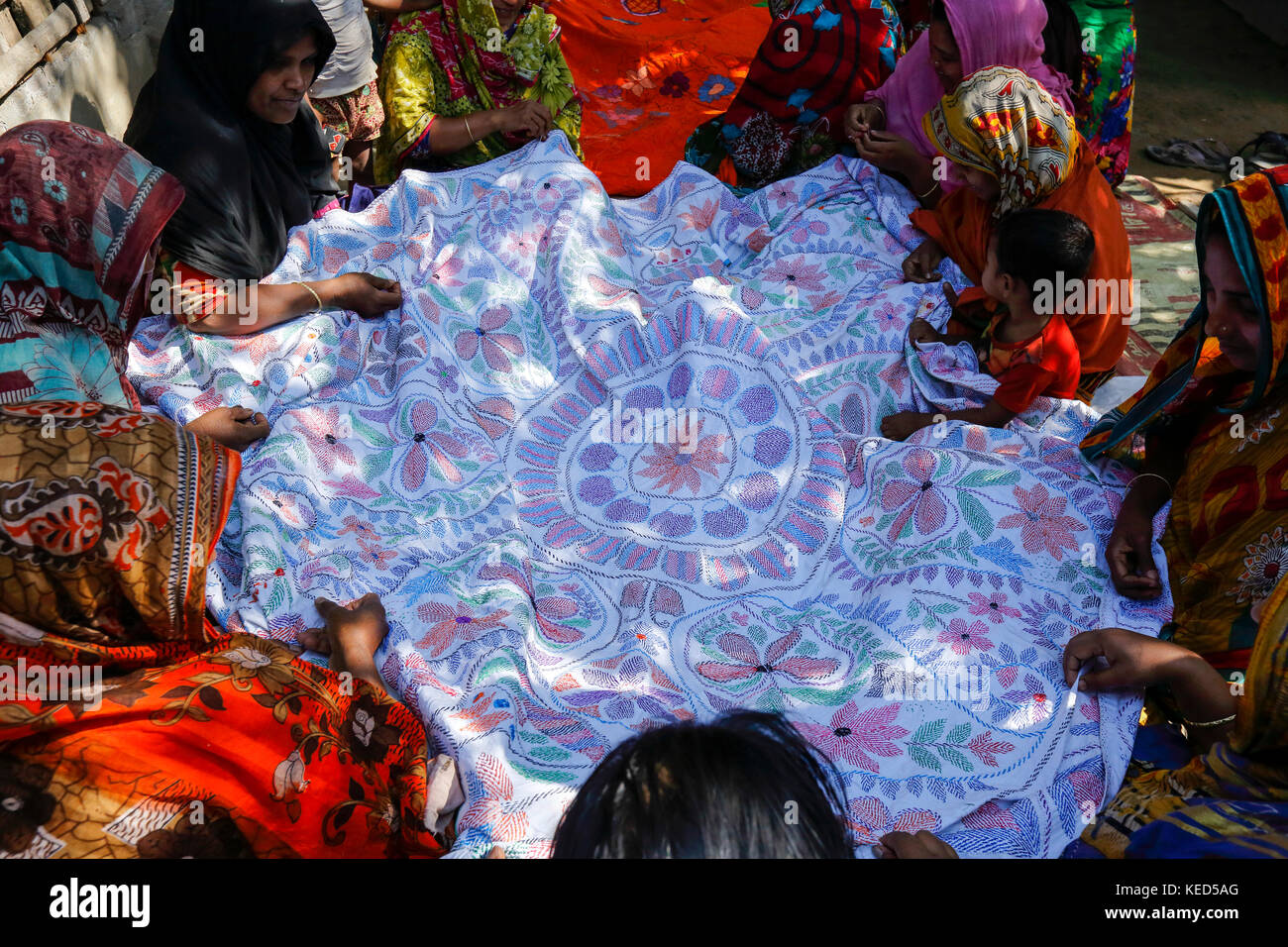 Rural women make Nakshi Kantha, a type of embroidered quilt at a Stock ...