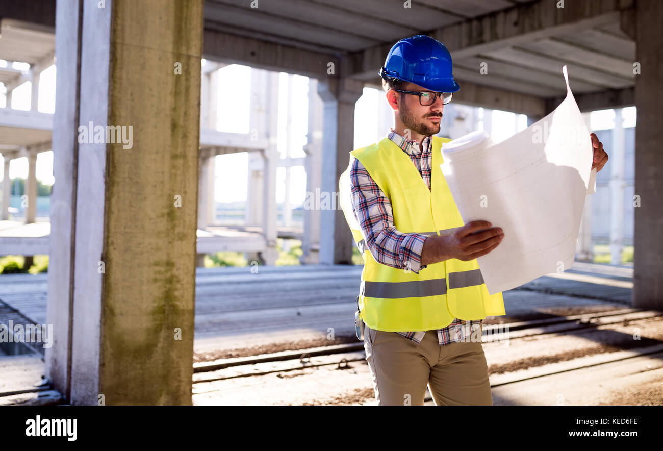 Picture of construction site engineer looking at plan Stock Photo