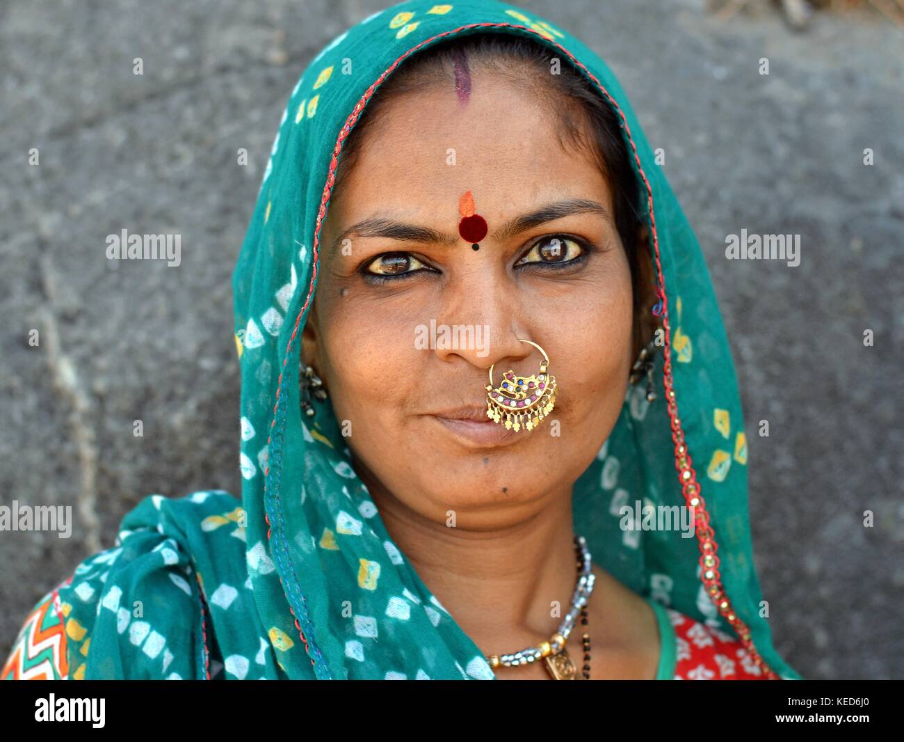 Head shot of a middle-aged Gujarati woman with green dupatta and precious traditional Indian nose jewellery Stock Photo