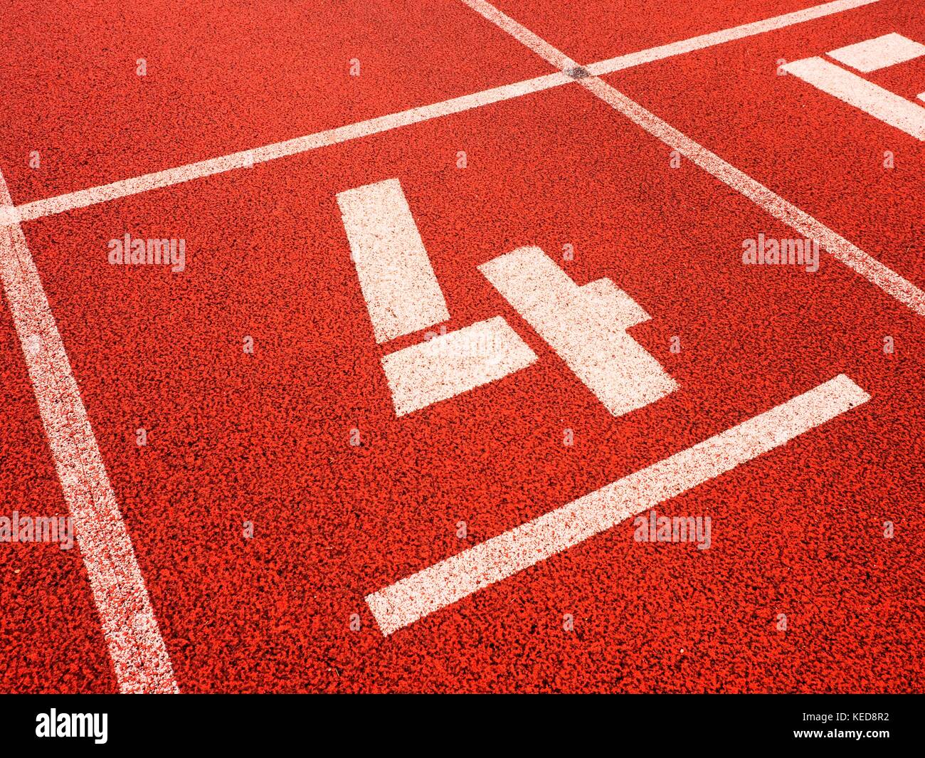 Number four. White track number on red rubber racetrack, texture of ...