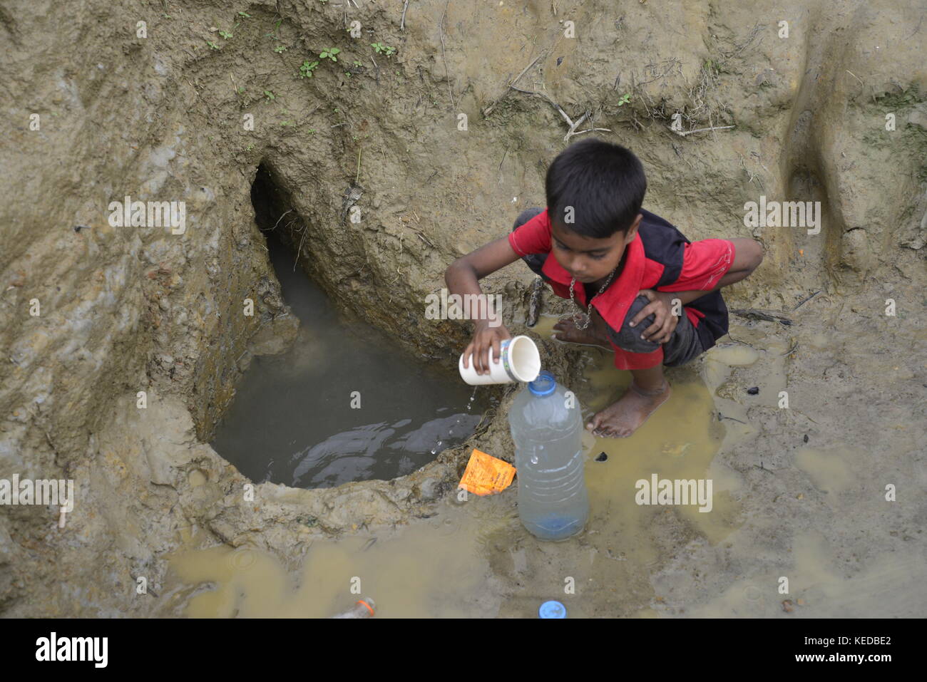 A Rohingya children are collects drinking water from the Mud hole at ...