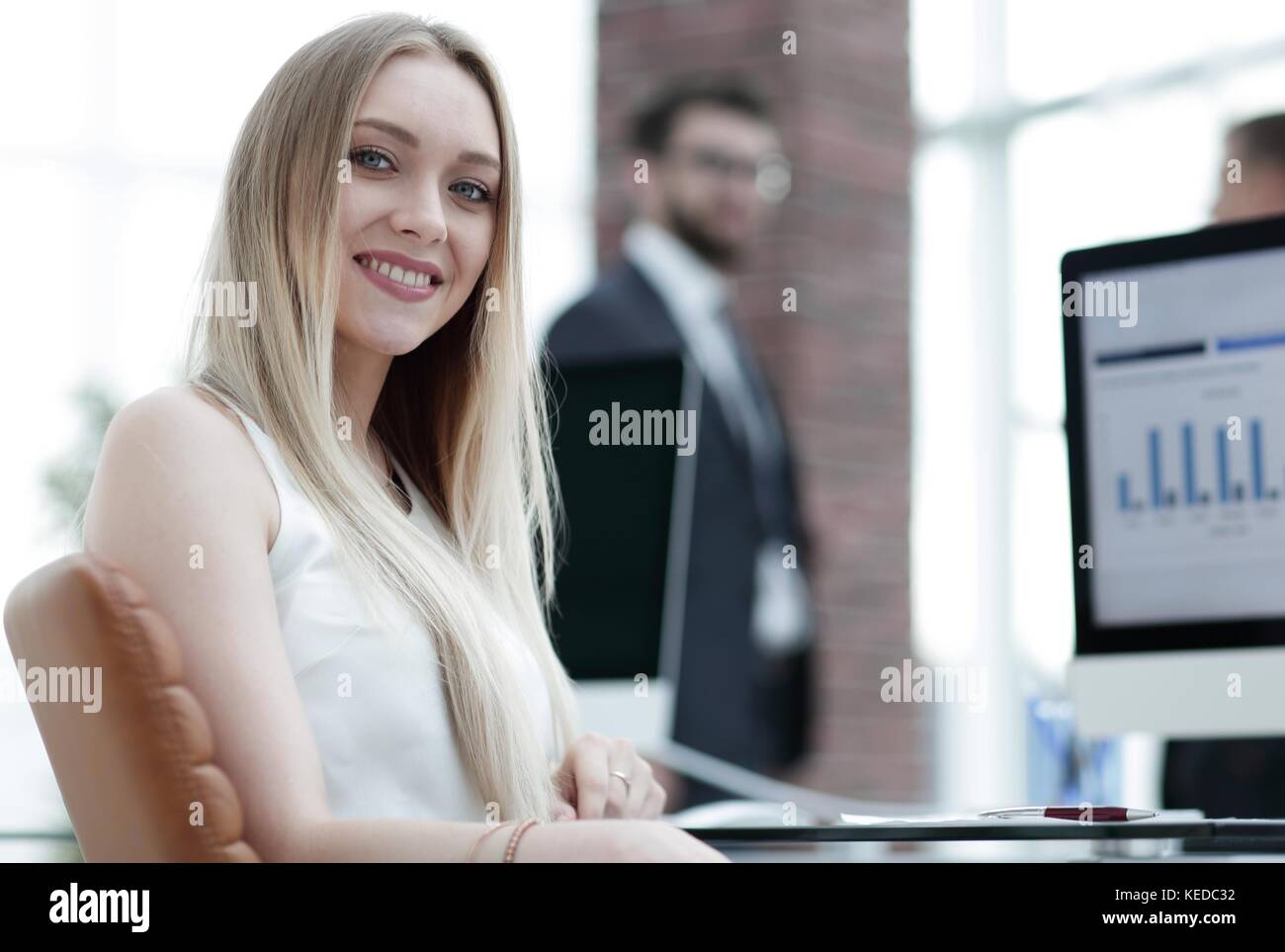 young business woman sitting at a desk in the office Stock Photo - Alamy