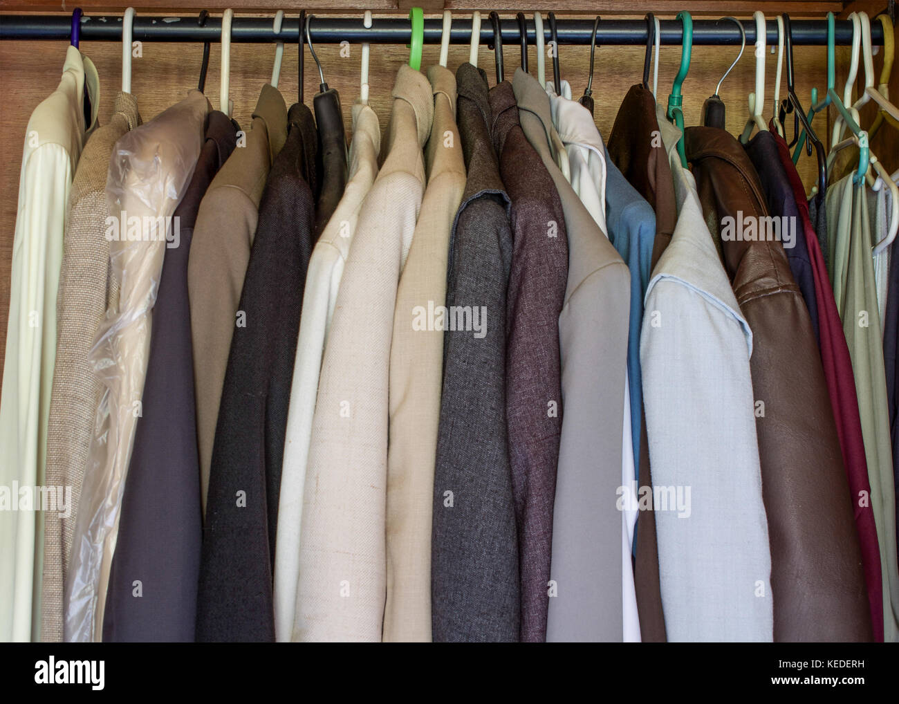 Mens clothes hanging inside a wardrobe close together, wardrobe is full Stock Photo