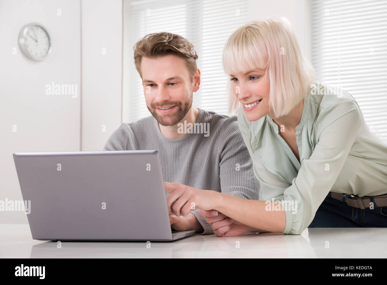Young Happy Couple Using Laptop On Desk Stock Photo - Alamy