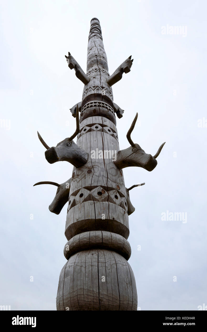 A wooden totem pole representing the idol surrounding the ancient settlement in the North of Russia Stock Photo