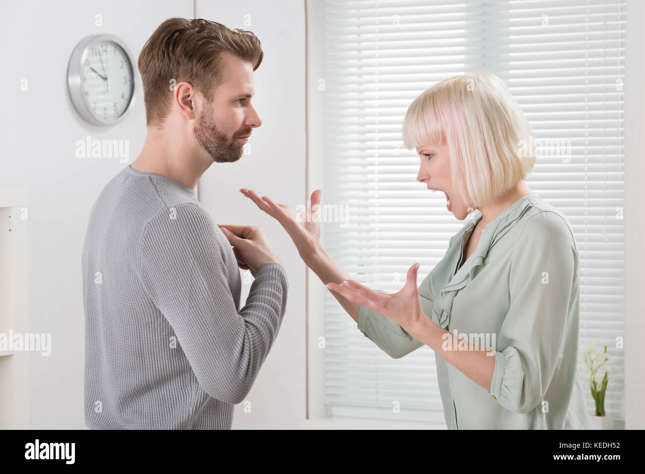 Unhappy Young Couple Arguing With Each Other At Home Stock Photo