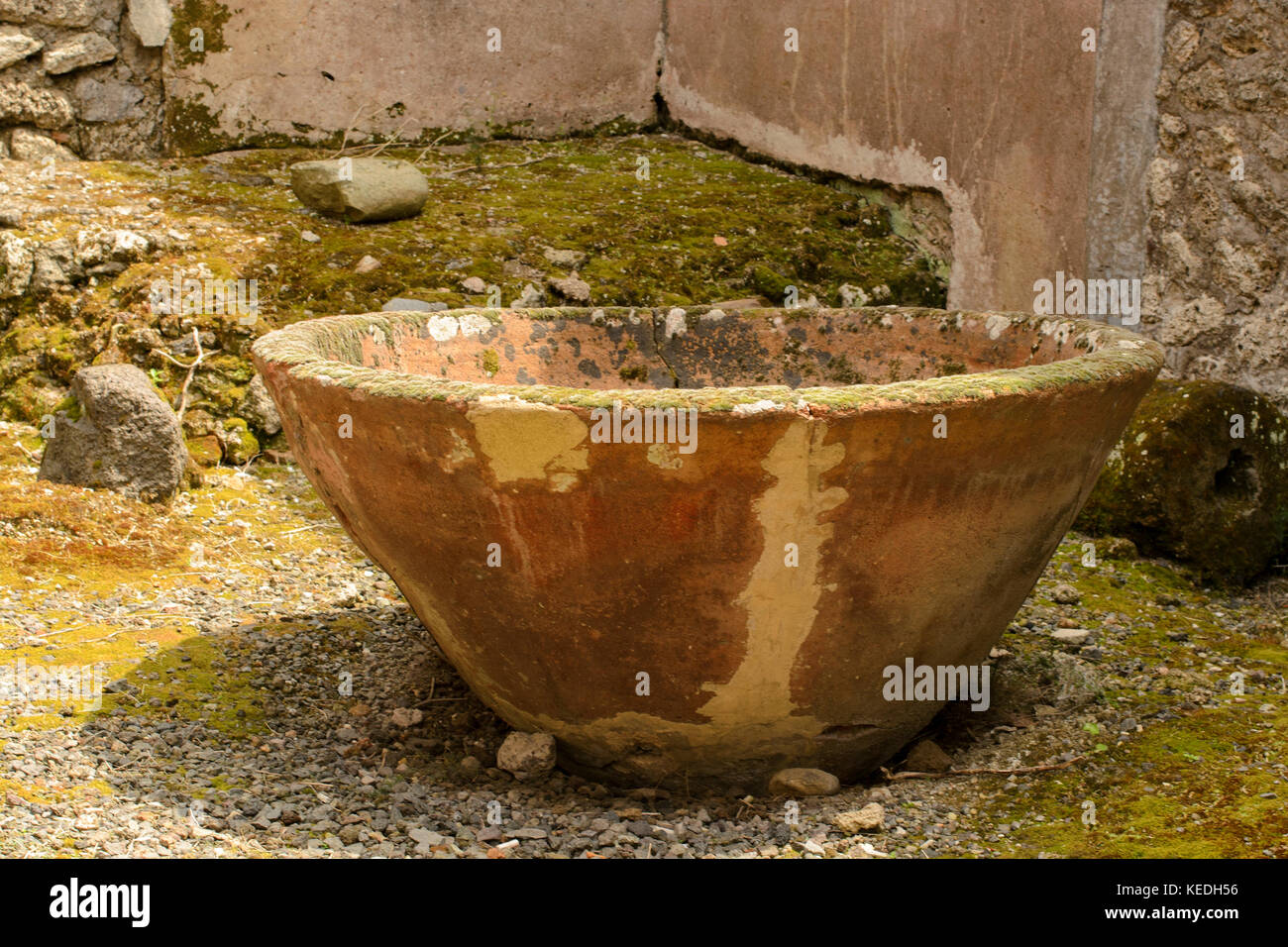 Antique vat overgrown with moss in ruins of Pompeii, Italy Stock Photo
