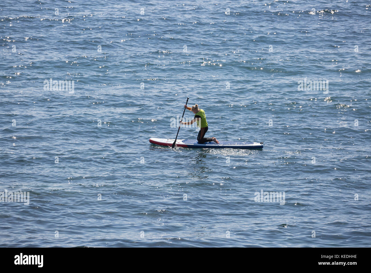 lady stand up paddle boarder kneeling paddle Stock Photo