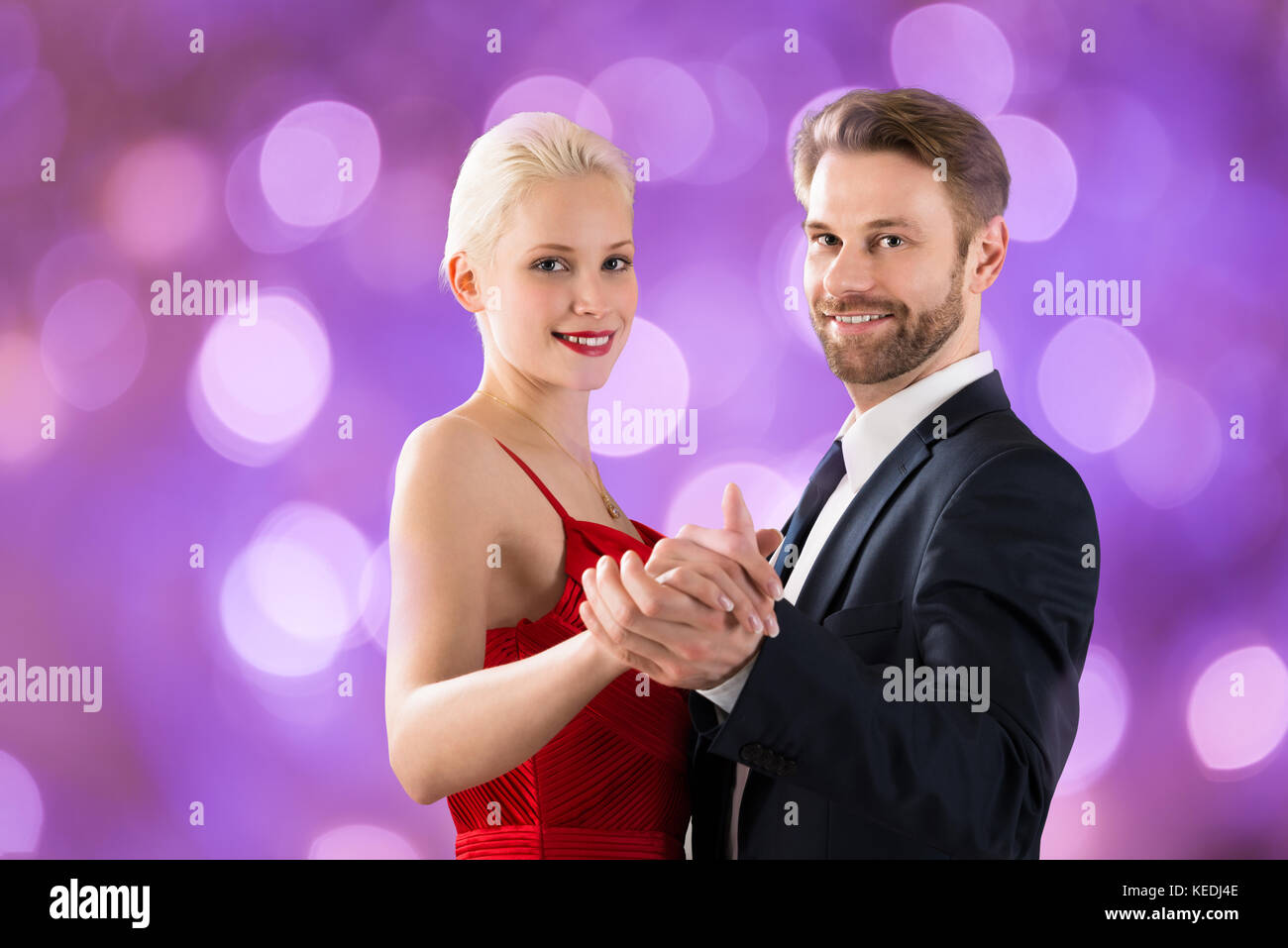 Portrait Of Young Happy Couple Dancing On Bokeh Background Stock Photo