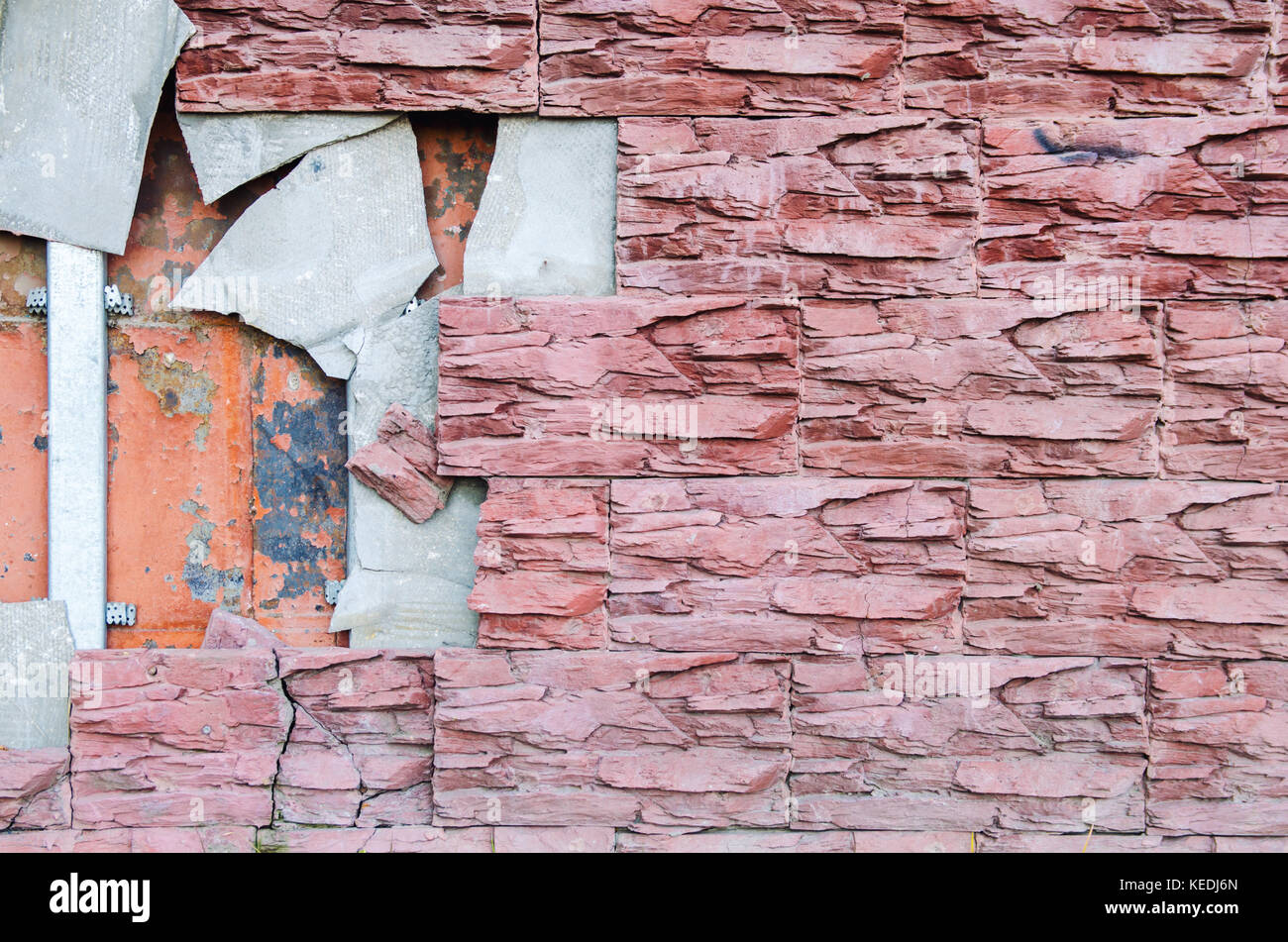 The broken tile on the tiled wall of the building requires repair Stock Photo