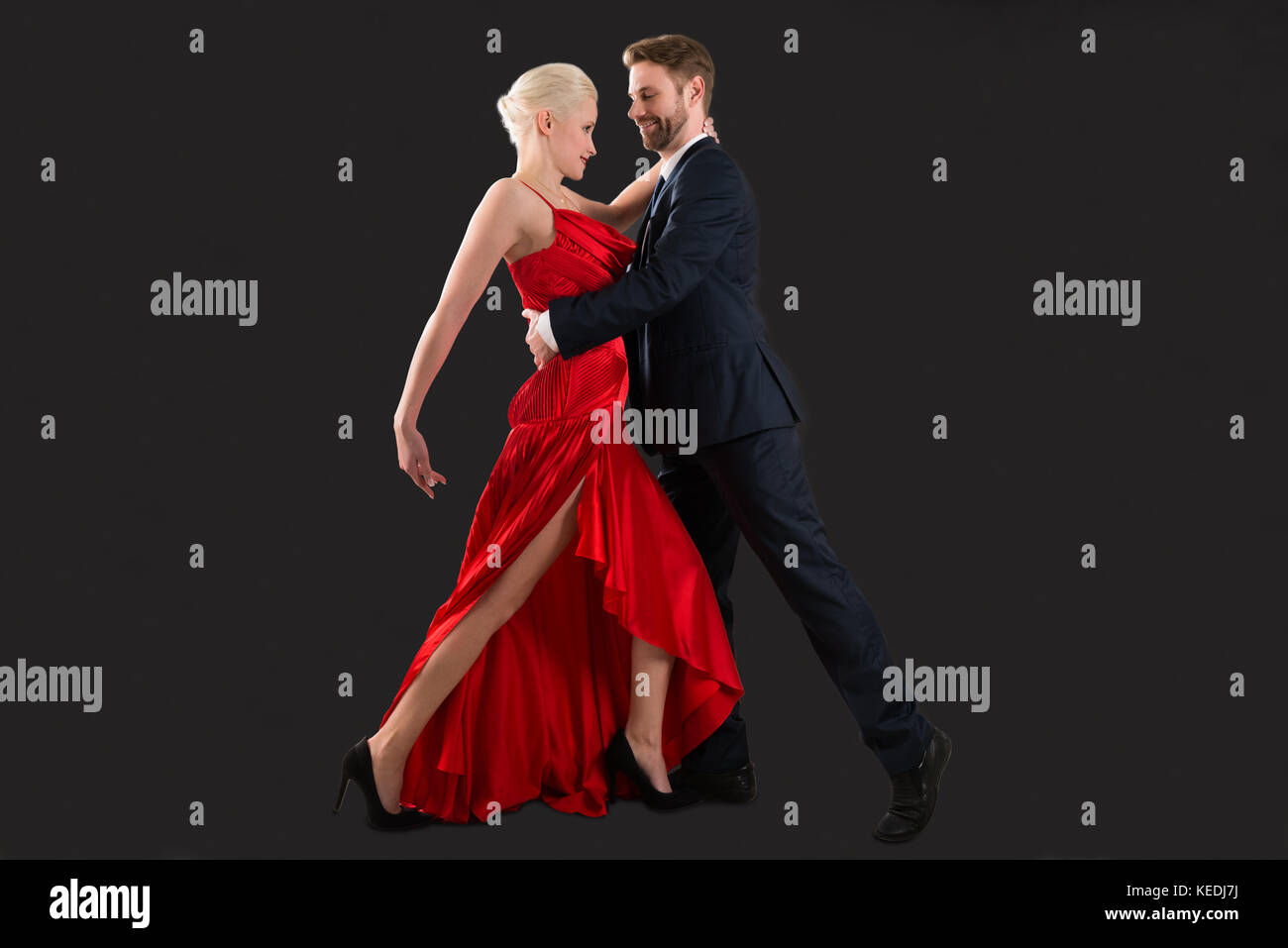Portrait Of Young Happy Couple Dancing On Black Background Stock Photo