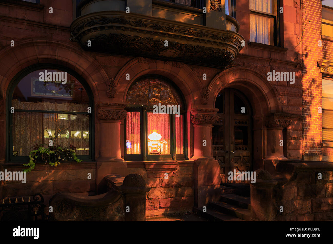 Downtown brownstone in Albany NY with lighting in vintage windows at