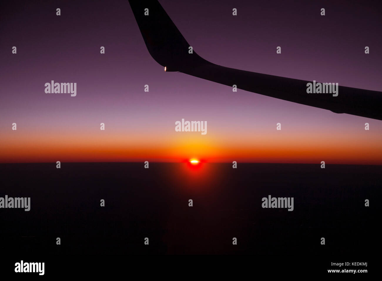 Wing of airplane in flight at sunset Stock Photo - Alamy