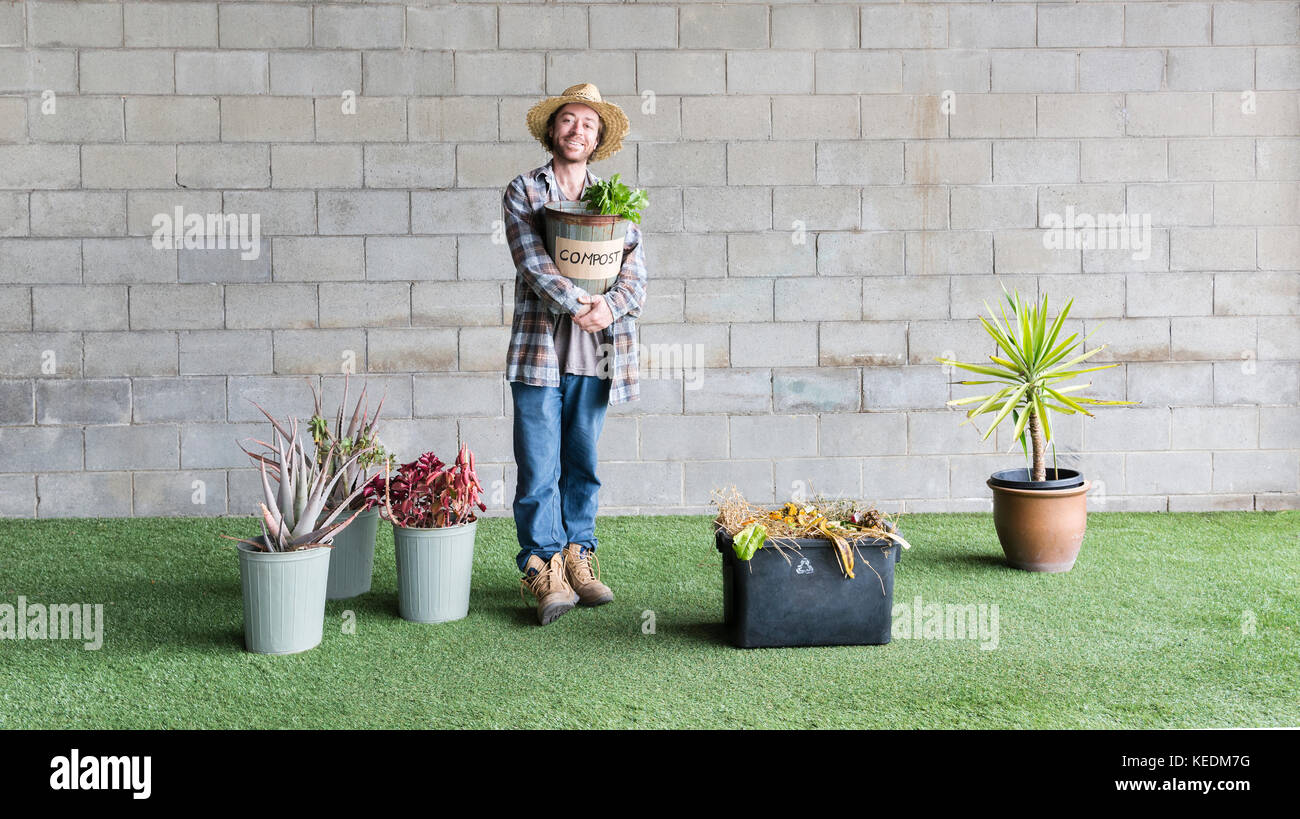 Man using food scraps for compost for his plants to promote environmental concept of 'Recover' Stock Photo