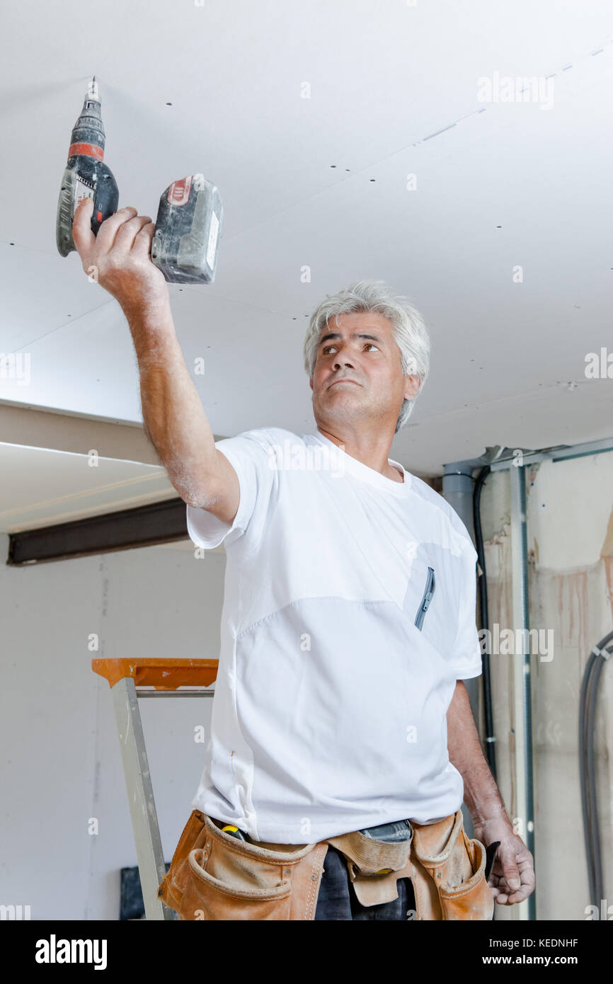 man drilling the ceiling Stock Photo