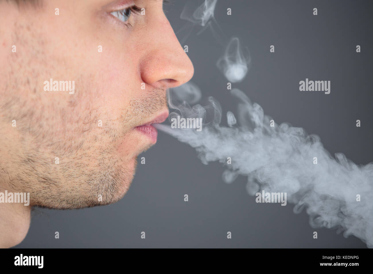 cigarette with smoke coming out of it man with smoke coming out from his mouth Stock Photo