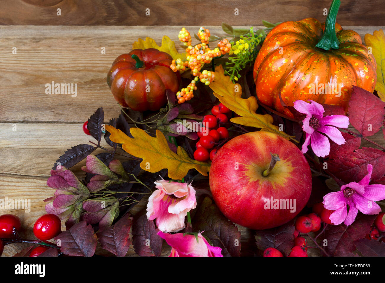 Fall rustic background with pumpkins, red berries, rowan leaves, apples ...
