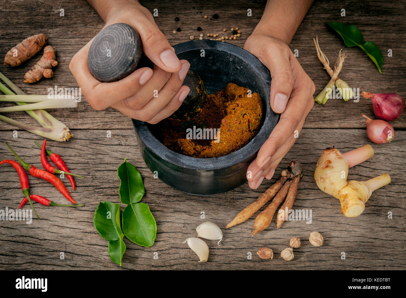The Women hold pestle with mortar and spice red curry paste ingredient