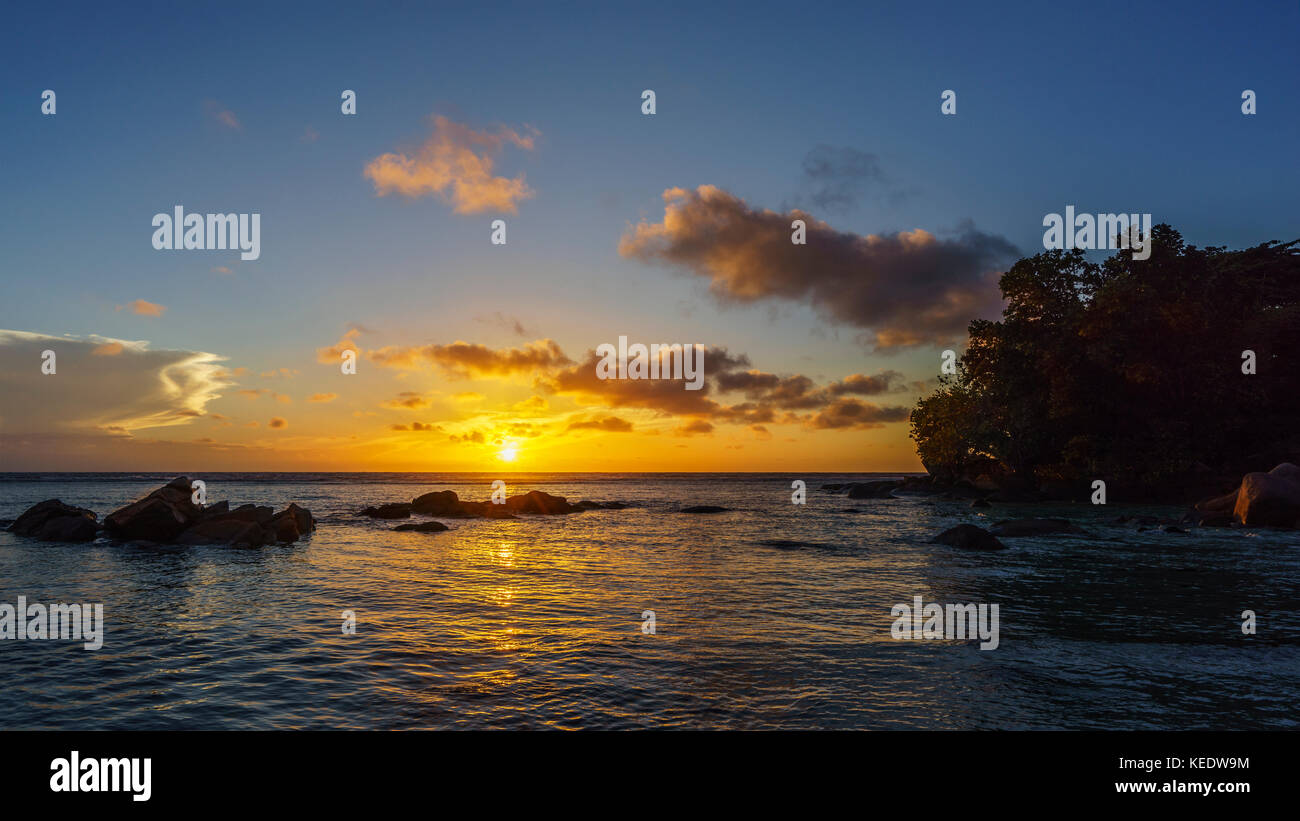 Sunset over granite rocks in the ocean on the seychelles. Stock Photo