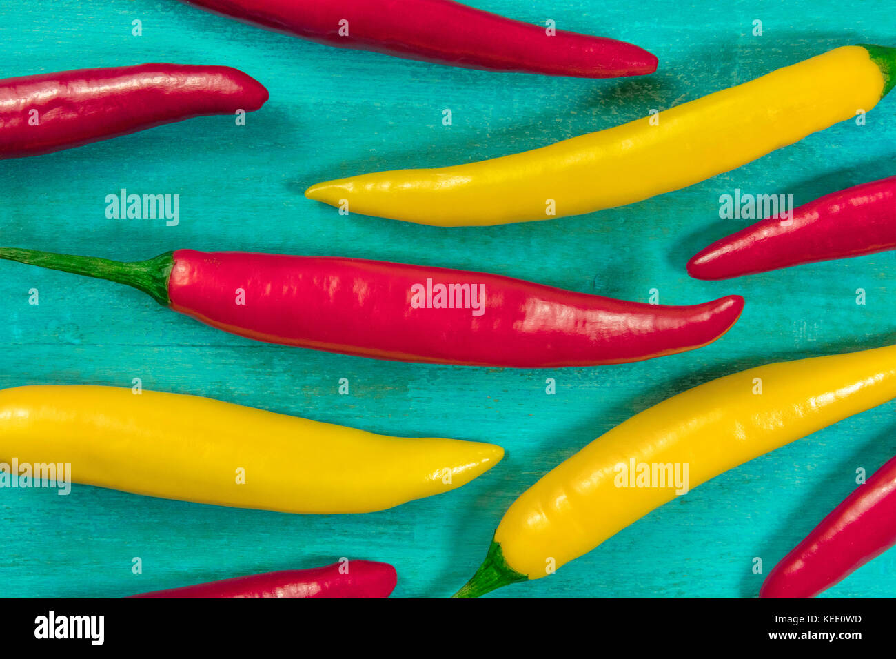 Red and yellow chili peppers on turquoise background Stock Photo - Alamy