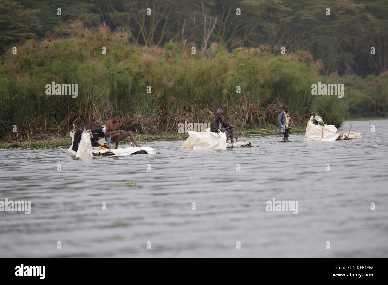 Local fishermen fishing from floating plastic rafts Lake Naivasha Kenya Stock Photo