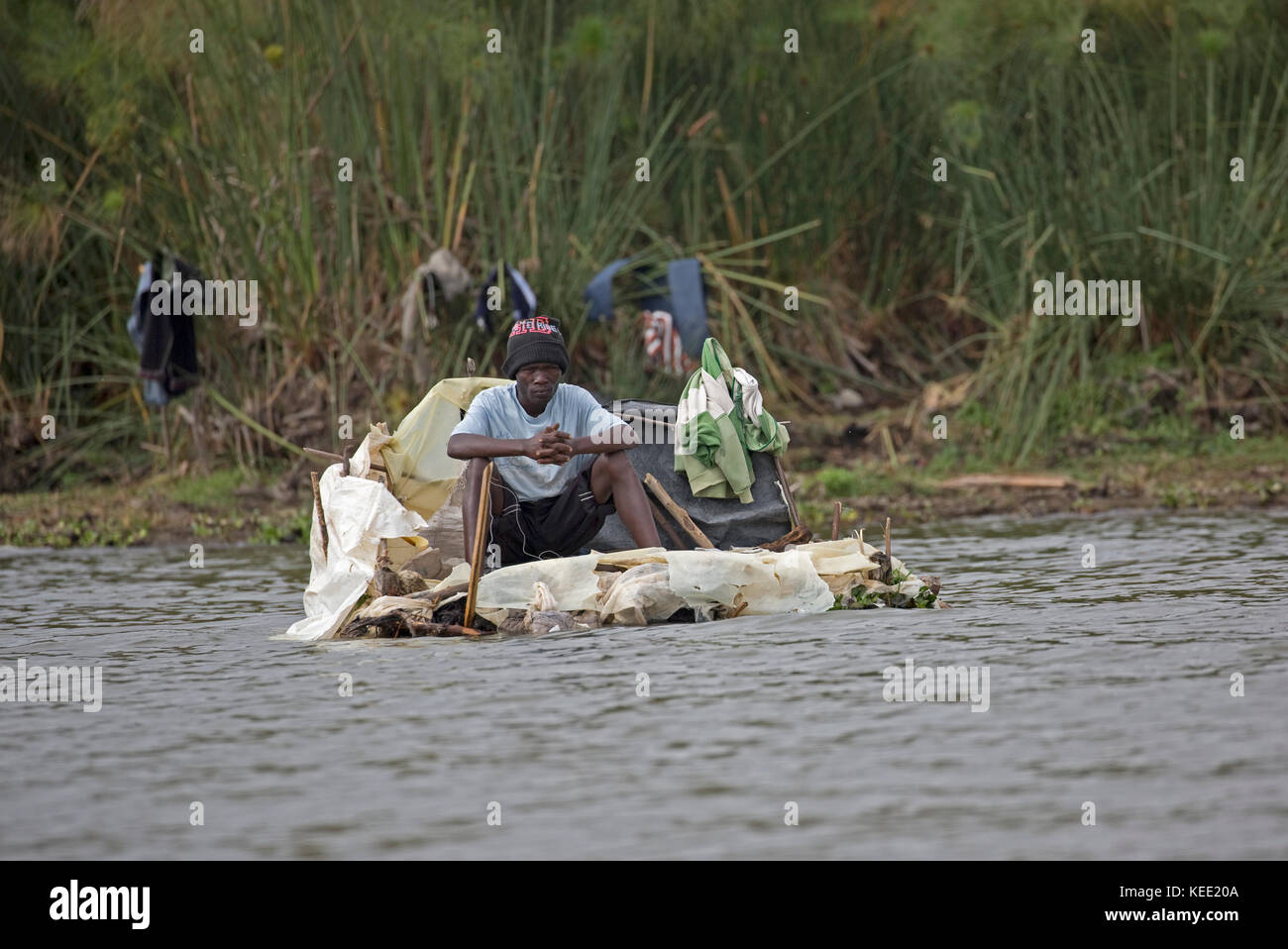 Local fisherman fishing from floating plastic raft Lake Naivasha Kenya Stock Photo