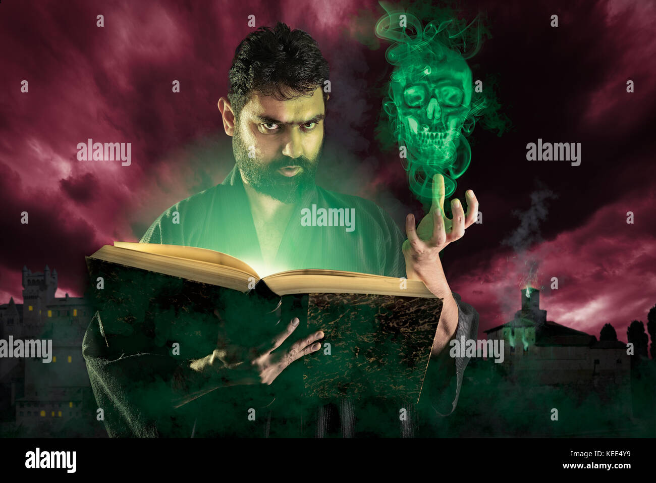 Male sorcerer casting a skull poison spell from a magic book as halloween image Stock Photo