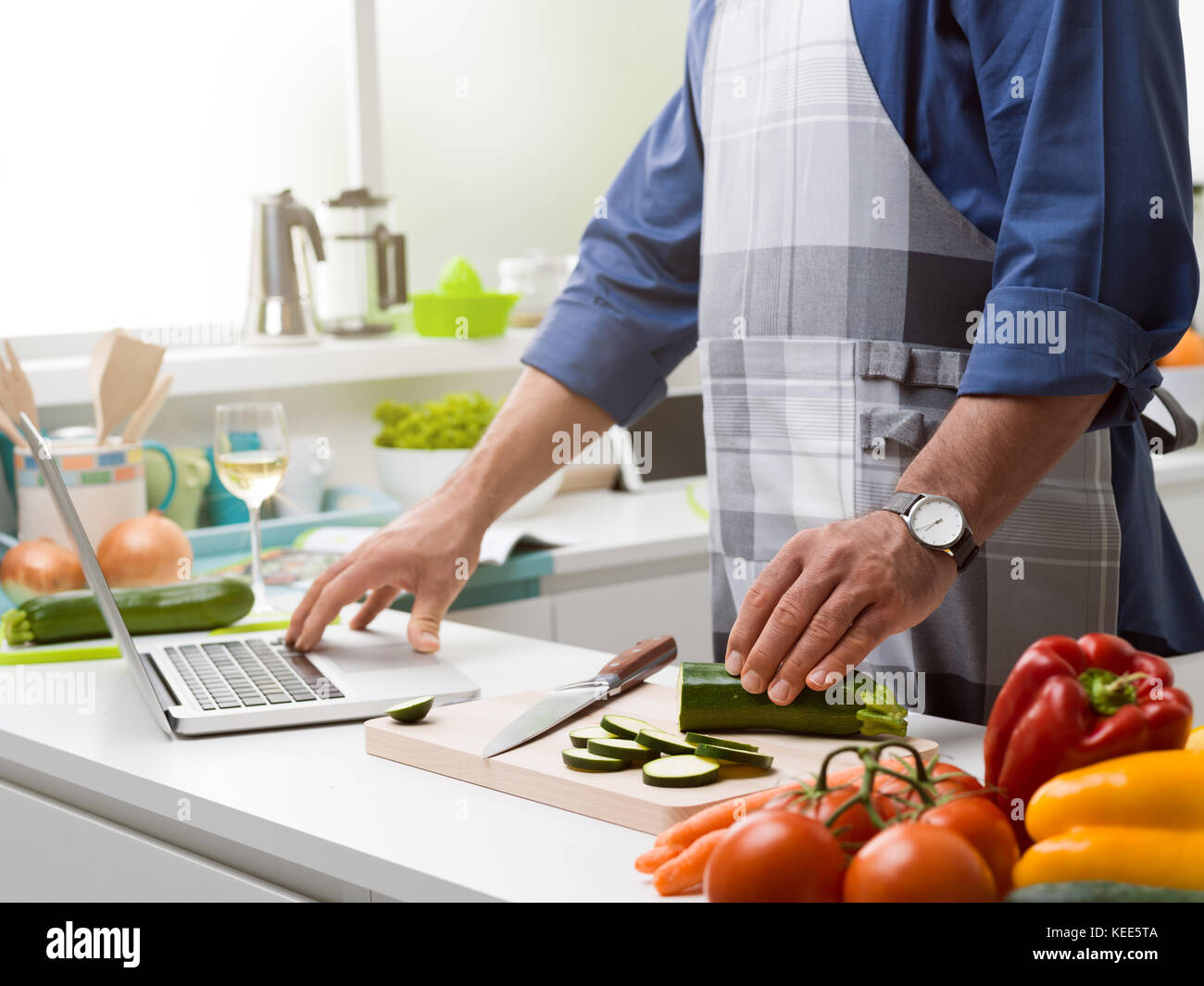 Man Using Kitchen Machine Man cooking in the kitchen and learning new recipes, he is connecting ...
