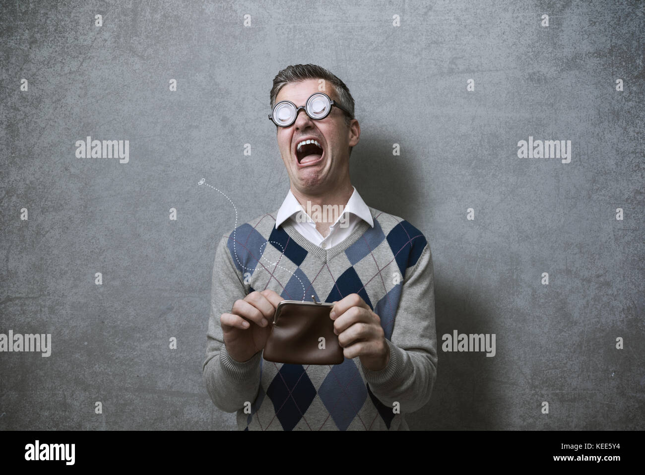 Broke man with thick glasses holding an empty purse and crying, poverty and debts concept Stock Photo
