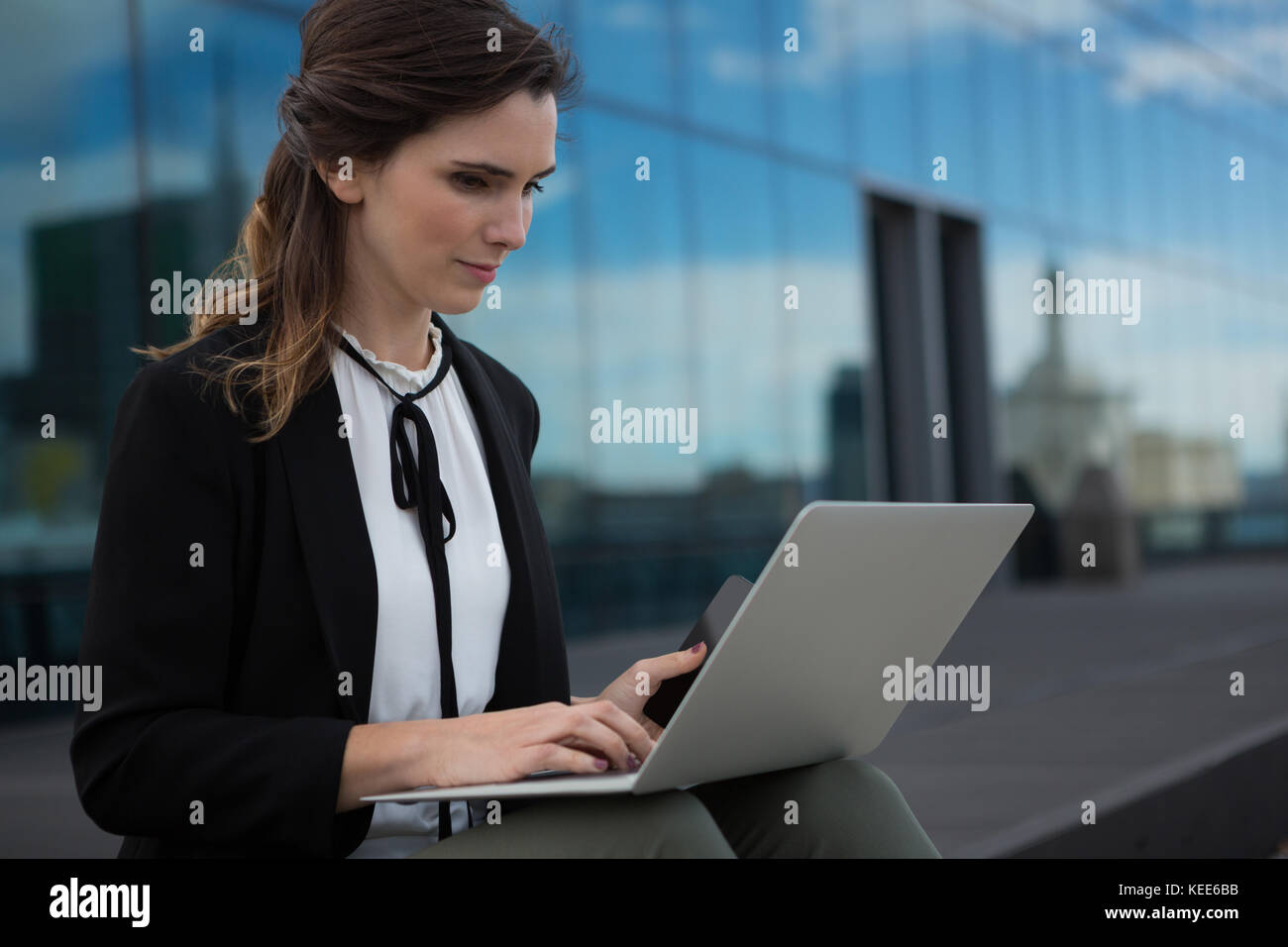 Female executive using laptop in office premises Stock Photo - Alamy