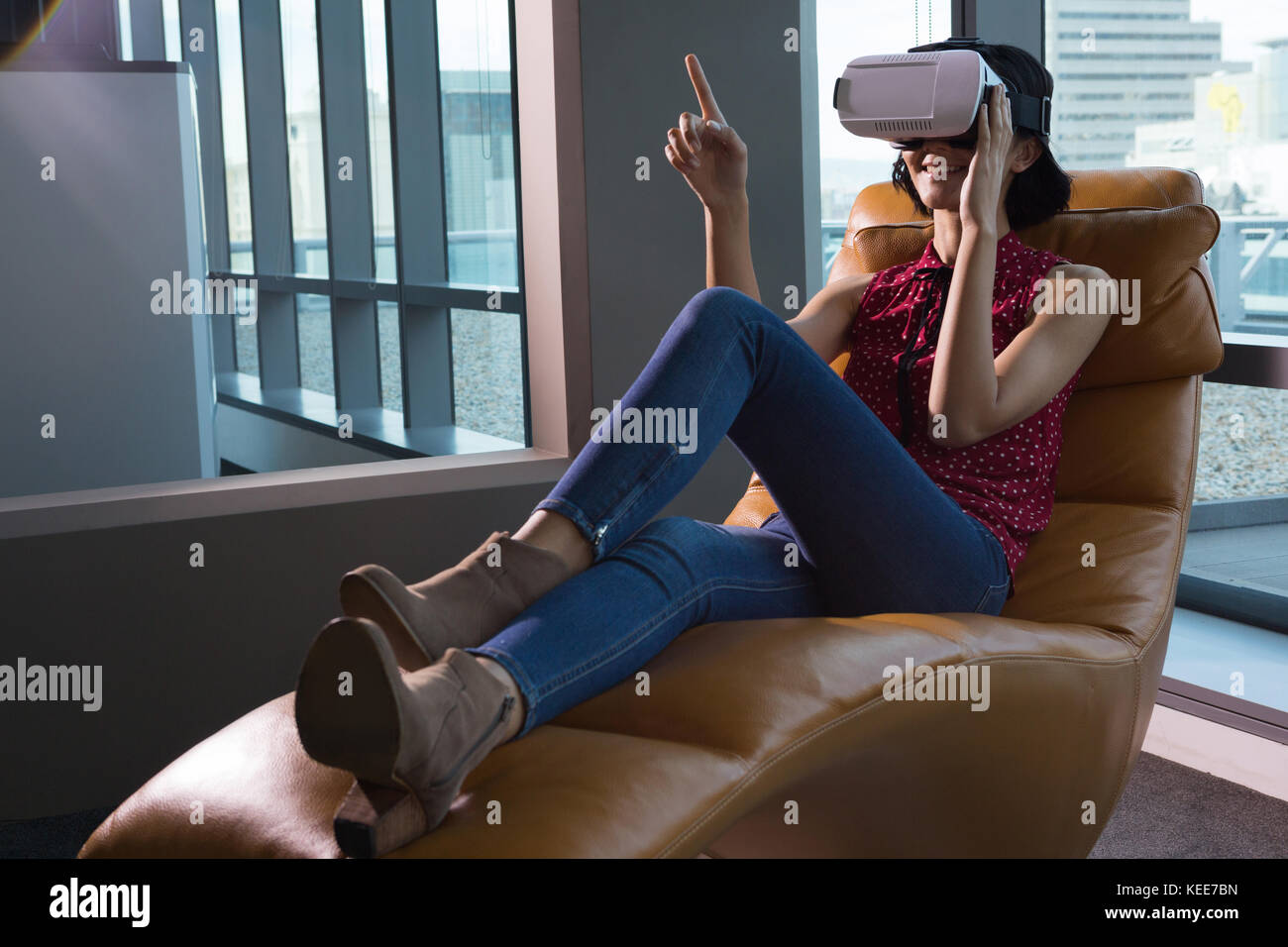 Female executive using virtual reality headset in futuristic office ...