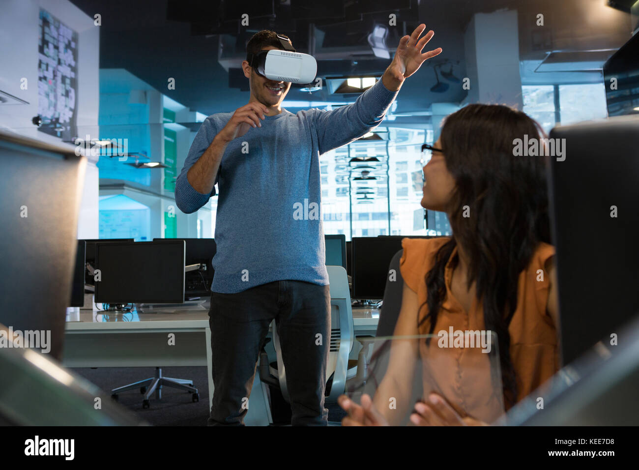 Executives using virtual reality headset at desk in office Stock Photo ...
