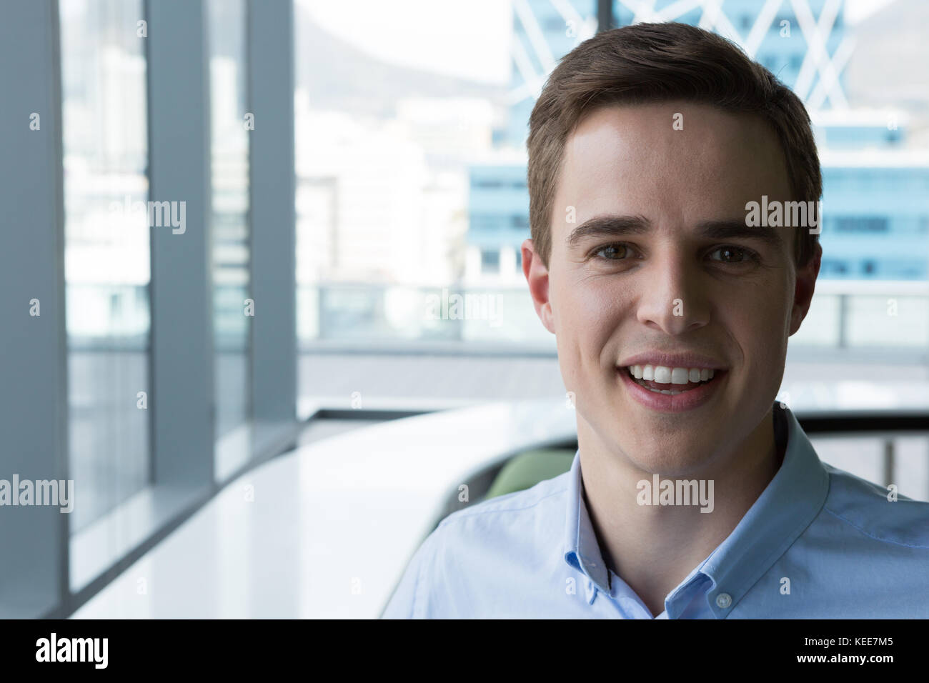 Young male executive smiling in office Stock Photo - Alamy