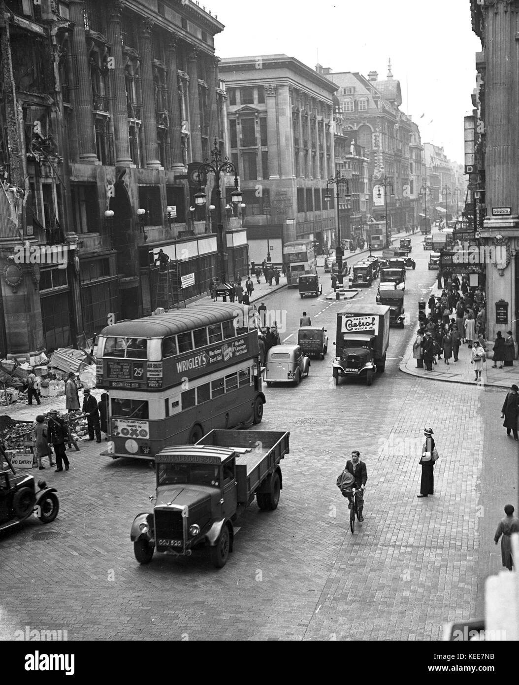 Oxford Circus, London c1942. Life going on as normal despite the effects of a bombing during World War 2, people going about their daily business as going to school or work, with buses and taxi cabs on the road alongside lorries and vans.  Photograph by Tony Henshaw -  From the wholly-owned original negative. Stock Photo