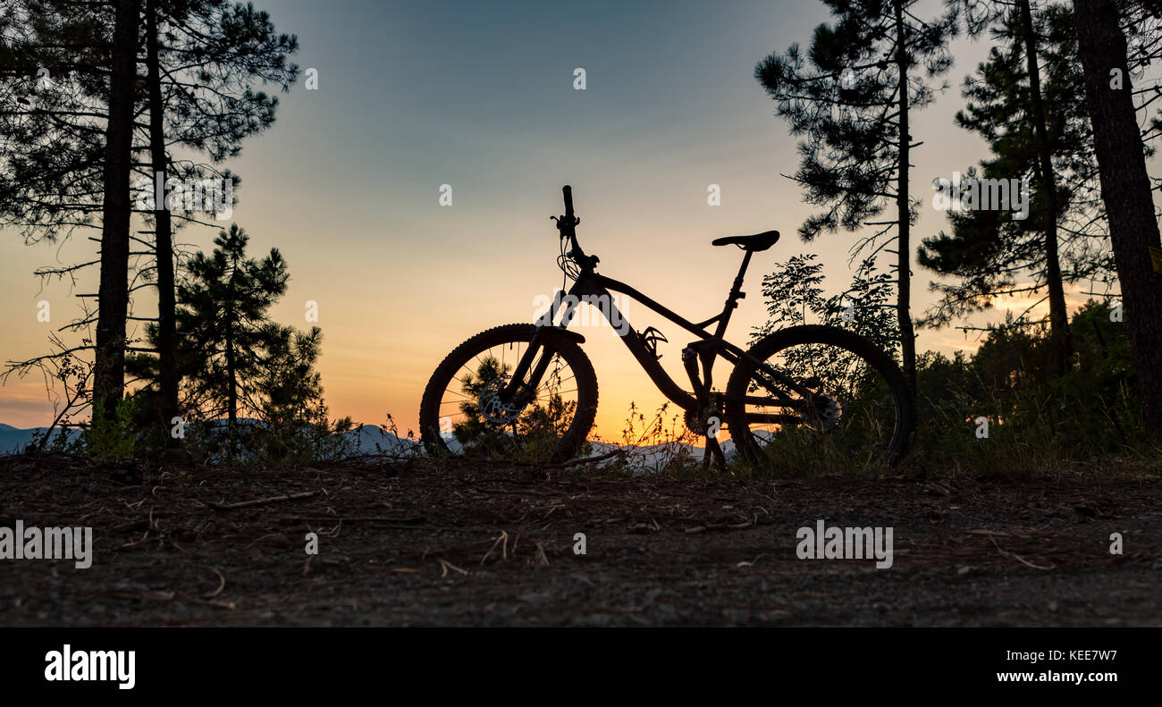 Mountain bike sunset silhouette on forest trail, inspiring landscape. Cycling bike on rural country road. Full suspension bicycle, inspirational sport Stock Photo