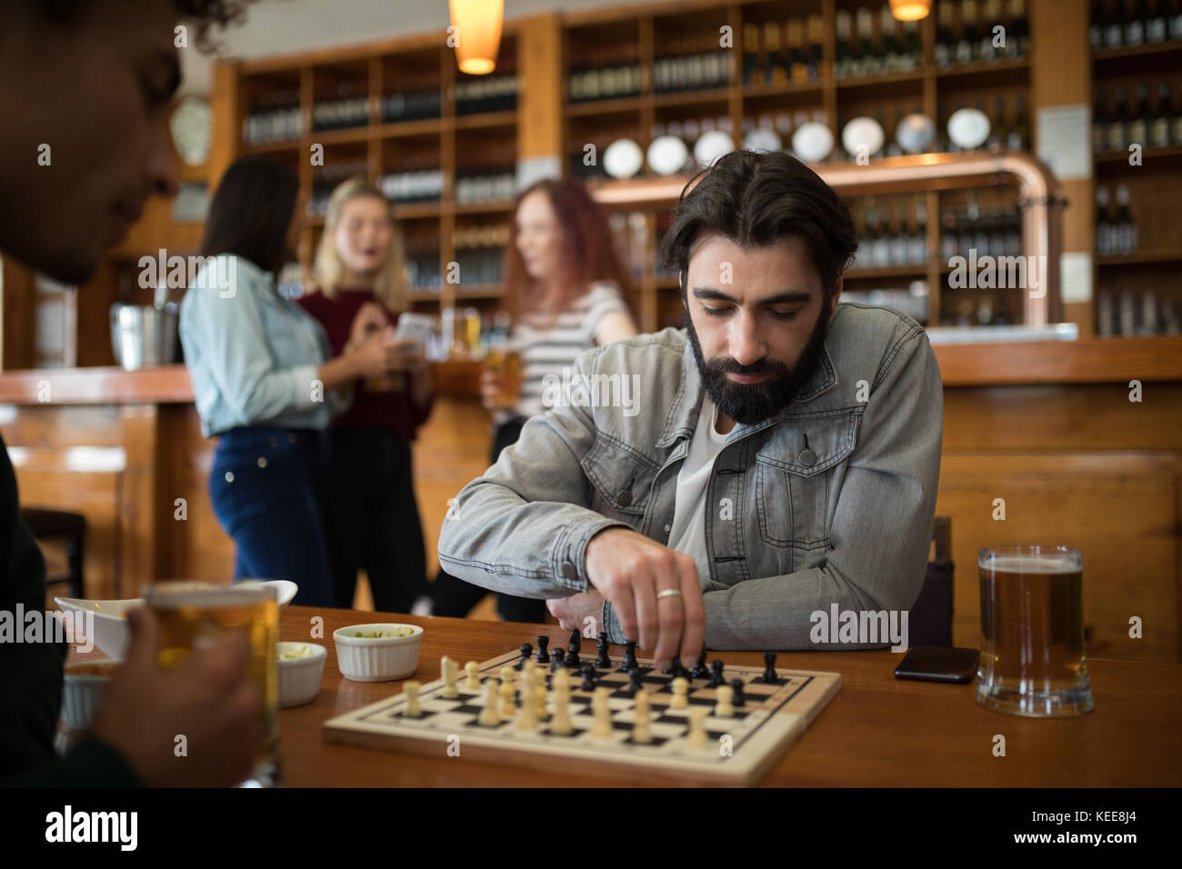 Two men sitting indoors playing a game of chess in hotel lounge Stock Photo  - Alamy