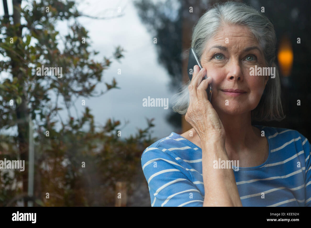 Senior woman talking on mobile phone in cafÃƒÂ© Stock Photo - Alamy